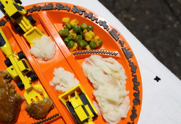 Construction Orange plate with healthy yummy dinner on Construction section plate with bulldozer pushing mash onto front loader spoon and forklift fork picking up broccoli
