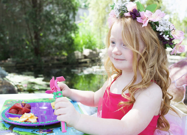 Cute Fairy Princess having fun eating with Garden Fairy Plate in a fairy garden